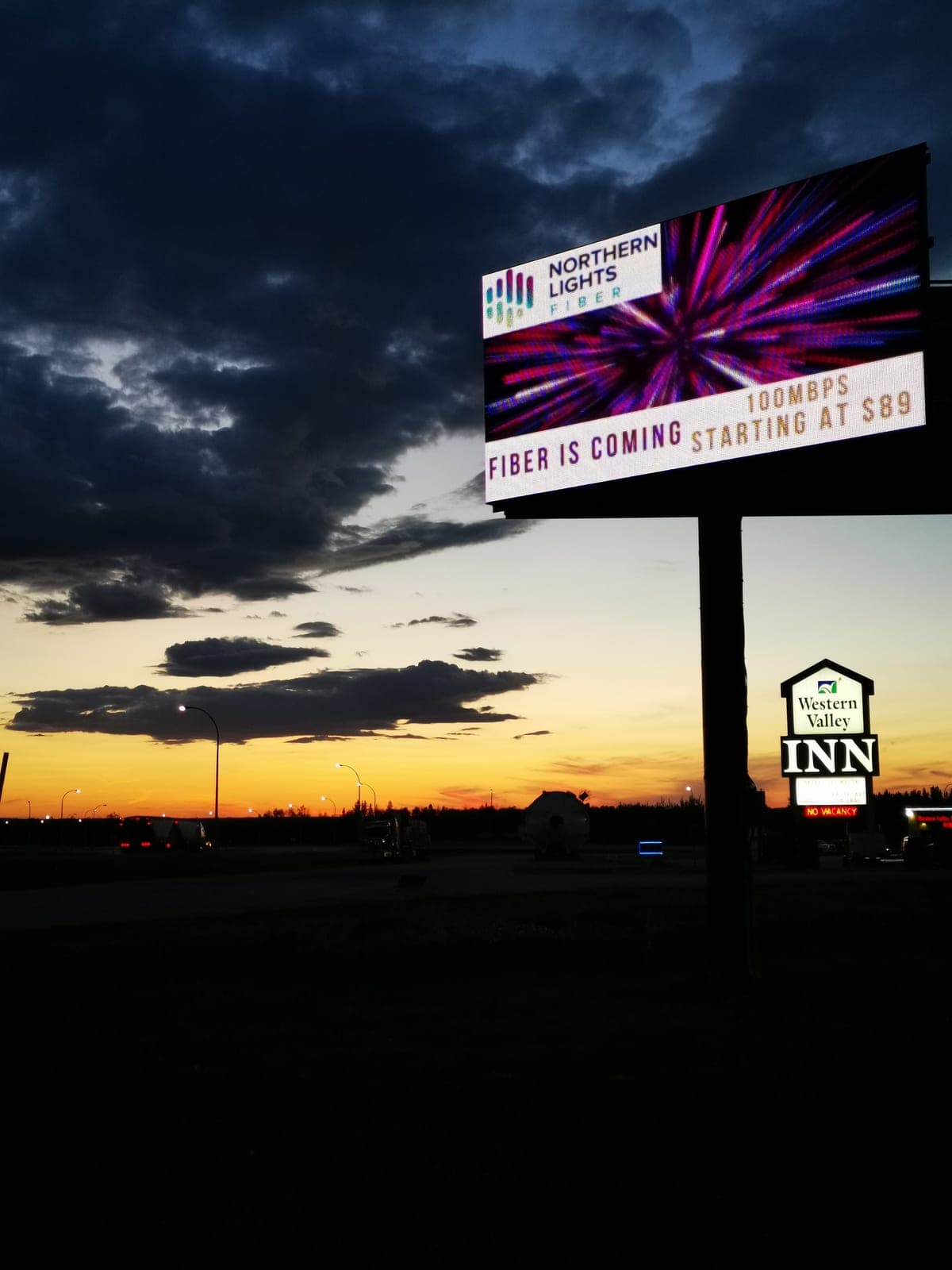 The MileAds digital billboard on Highway 43 at sunset, running a local advertiser's ad